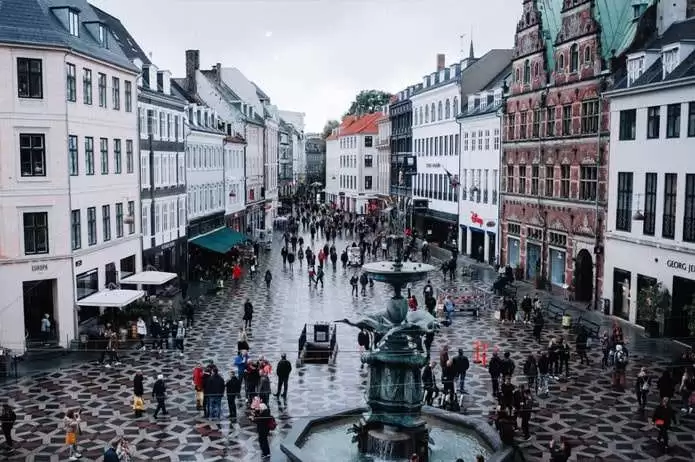 Danimarka Türk Diyanet Vakfı web sitesi projesini anlatan liste görseli, fotoğrafta Danimarka da bir meydan ve meydanda bir çok insanın dolaştığı görülmektedir.