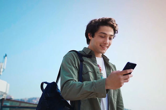 Yıldız Teknik Üniversitesi web sitesi projesini anlatan liste görseli, fotoğrafta elinde telefon olan genç bir kişi vardır